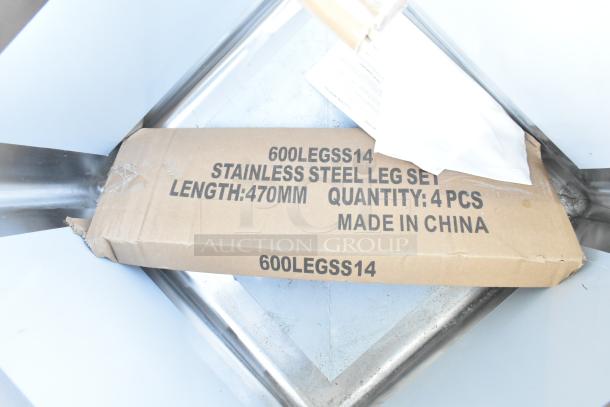 Cardboard box labeled “600LEGSS14 Stainless Steel Leg Set Length: 470mm Quantity: 4 Pcs Made in China,” on stainless steel surface.