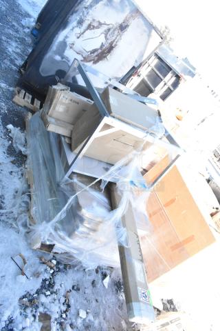 Stack of 12 new scratch and dent items including tabletops, shelf, folding table, packed in boxes on a pallet.