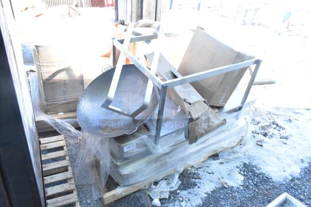 12 brand new scratch-and-dent items including tabletops, shelf, folding table. Items are stacked on a pallet with visible packaging wear.