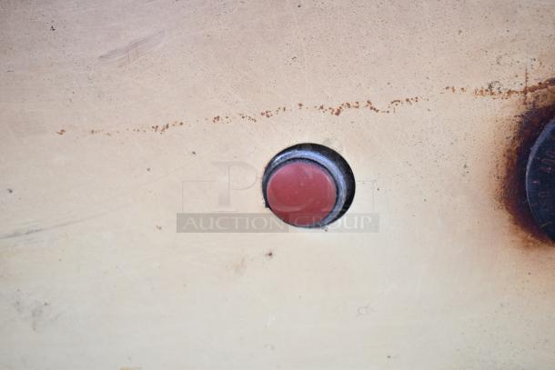 Control panel of Montague 24P-2 pizza oven, featuring a red button. Some visible wear and rust indicating used condition.