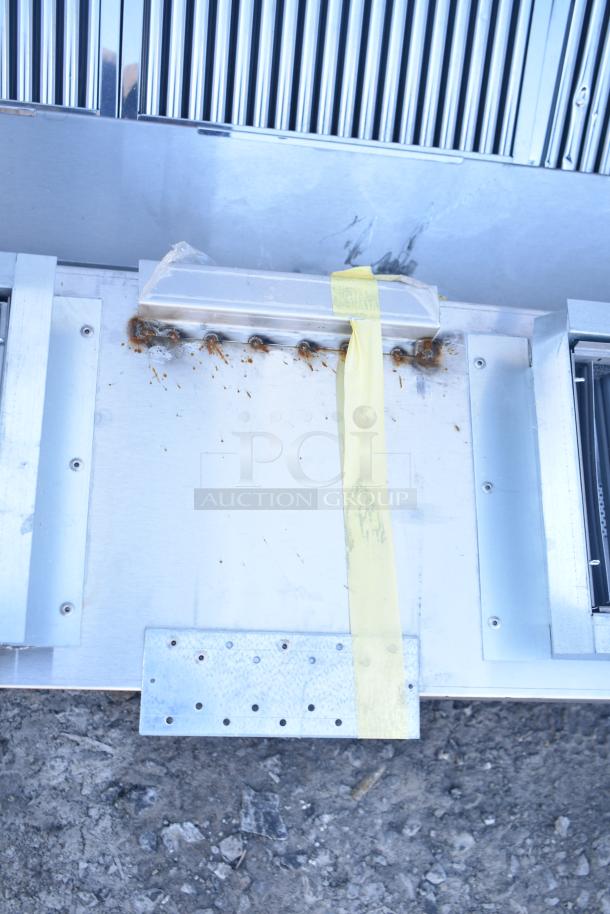 Brand new CaptiveAire 6024 ND-2WI commercial return air grease hood, stainless steel with filters and lights, minor dents visible.