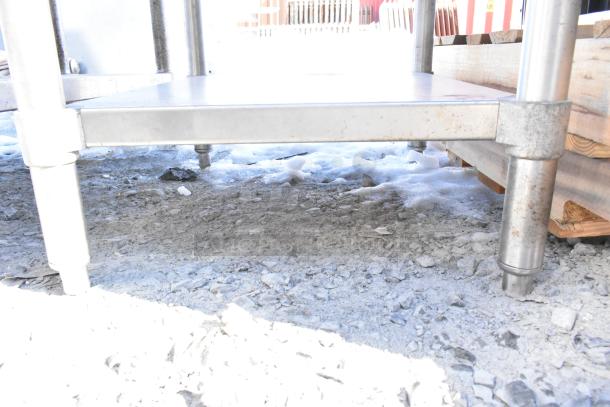 Steel commercial table with under shelf, sturdy construction, adjustable legs, ideal for kitchen or industrial use.