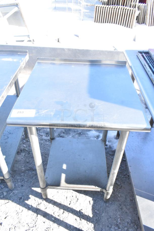 Commercial stainless steel table with under shelf, rectangular top, sturdy legs, label marked "253", used condition.