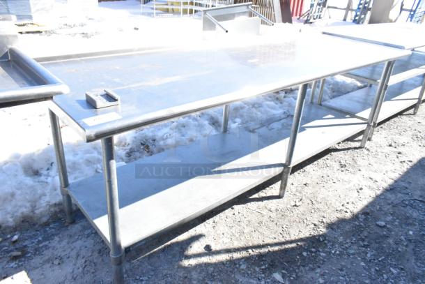 Commercial stainless steel table with under shelf and vegetable slicer mount. Good condition, sturdy construction.
