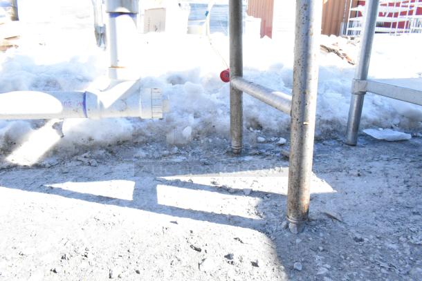 Commercial 3 bay sink with dual drain boards, faucet, handles, and spray nozzle attachment, shown in an outdoor setting.