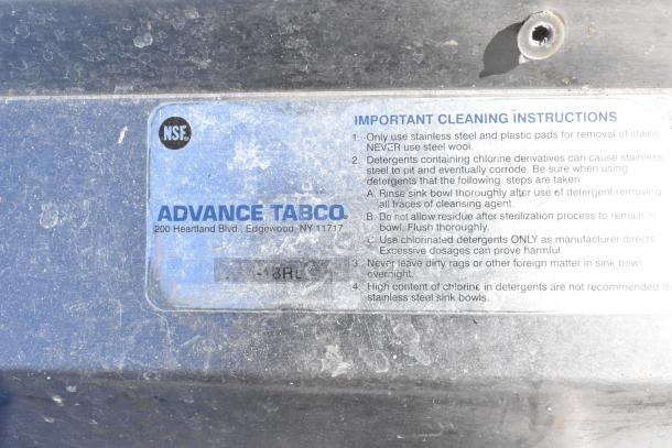 Plaque on Commercial 3 Bay Sink with Advance Tabco branding and cleaning instructions. Rust and wear visible.