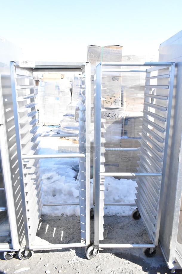 Two commercial pan transport racks with multiple slots, mounted on durable commercial casters, in good condition.