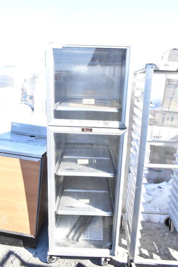 Lockwood enclosed pan transport rack on commercial casters, silver finish, visible Lockwood label, used condition.