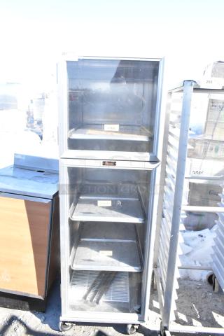 Lockwood enclosed pan transport rack on commercial casters, silver finish, visible Lockwood label, used condition.