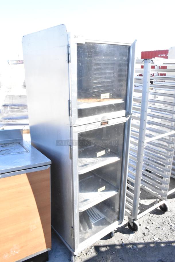 Lockwood commercial enclosed pan transport rack on casters; features multiple shelves; used condition with visible wear.