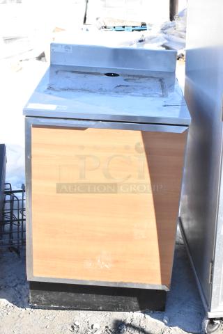 Duke SUBP-24M counter with wood pattern door, stainless steel top, some surface wear visible, suitable for commercial use.