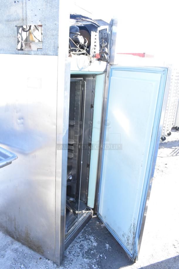Commercial single door reach-in cooler, stainless steel, open door, visible shelving, fair condition.