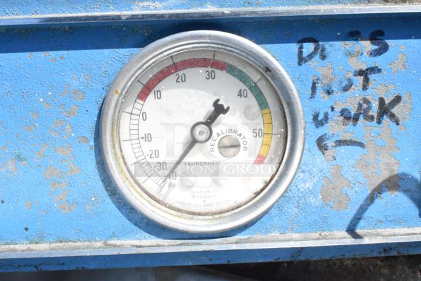 Gauge on a blue cooler with markings indicating it does not work, showing temperature range in Fahrenheit.