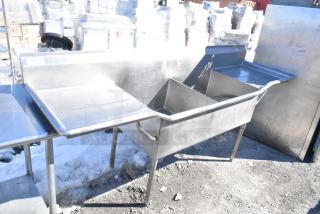 Commercial 2 bay sink with dual drain boards, stainless steel, good condition, sturdy legs, ideal for restaurant use.