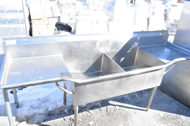 Commercial 2 Bay Sink with dual drain boards, stainless steel, used condition, durable construction. Slight wear visible.