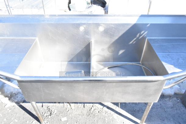 Commercial 2 Bay Sink with Dual Drain Boards, stainless steel, visible wear. Dual faucet holes and spray hose included.