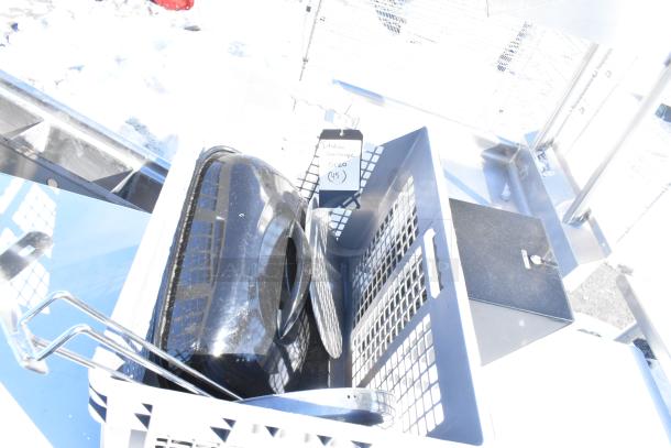 Lot of various items in a gray bin, including a black lid, kitchen accessories, and a label reading "Italian Sausage". Items show outdoor exposure.