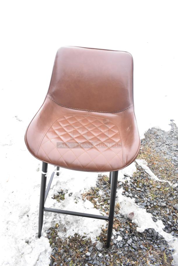 Brown chair with quilted leather seat, black metal legs. Scratch and dent condition, one of 12 assorted new items.