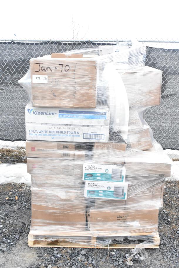 Plastic-wrapped pallet with assorted scratch and dent items, including towel dispensers and boxes labeled "KleenLine" towels.