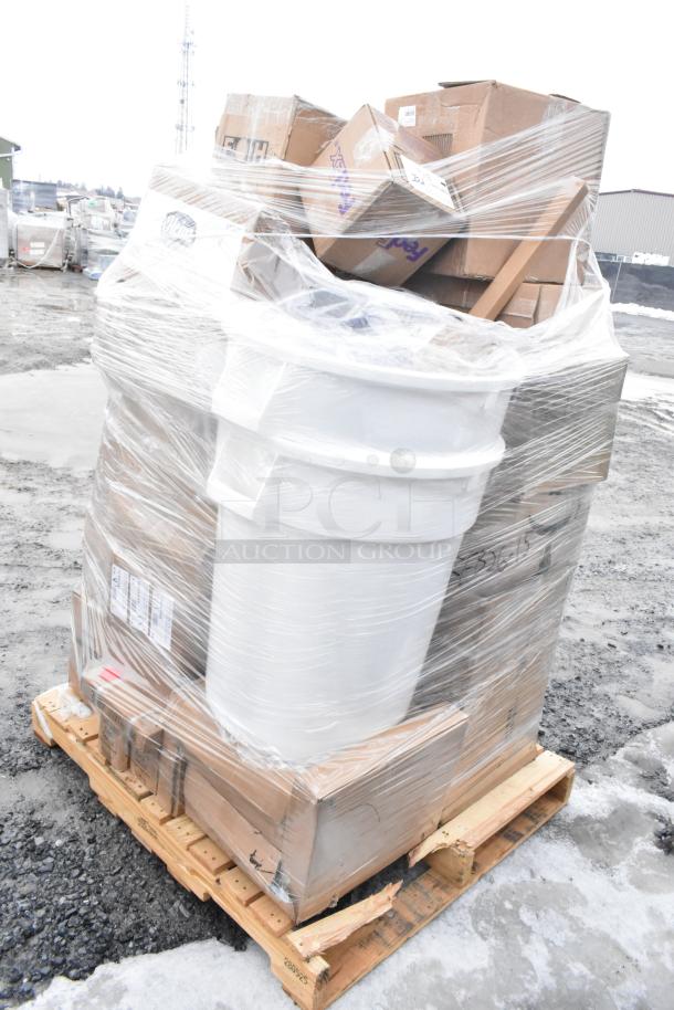 Stack of brand new scratch and dent items on pallet, wrapped in plastic. Visible cardboard boxes and a white bin.