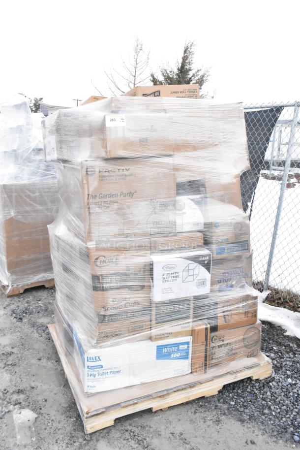 Pallet of assorted boxes with various items including gloves, towels, and bags, wrapped in plastic. Some boxes show brand names and labels.