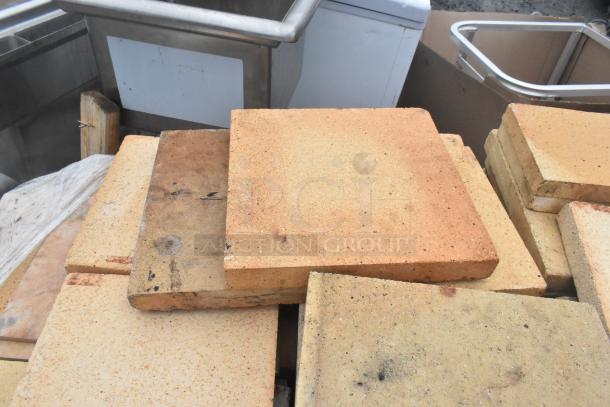 200 pizza oven cooking stones, lightly used, varied colors, stacked. High-quality material, ideal for even heat distribution.