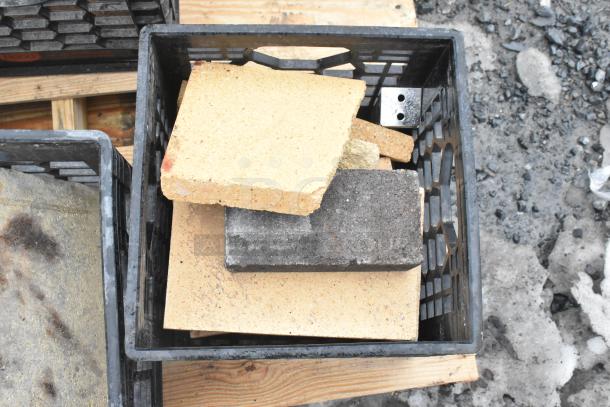 Pallet lot with assorted items, including yellow and gray cooking stones for pizza ovens, and metal legs, in crates.