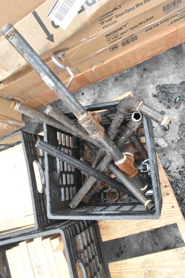 Pallet lot including metal pipes in crate and boxes marked "Regency 18x48 Wire Shelf." Items appear used.
