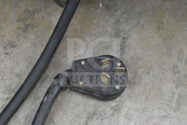 Close-up of the power plug for a Taylor 794-27 commercial soft serve ice cream machine. Visible are three metal prongs.