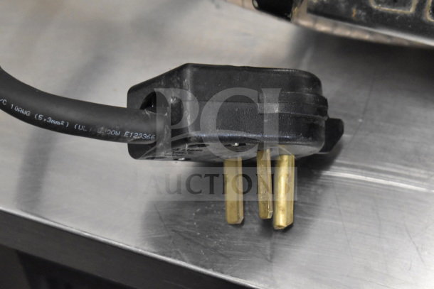 Close-up of a black power plug and cord for the Vela Commercial Countertop 3 Group Espresso Machine.