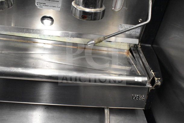 Vela Commercial Countertop 3 Group Espresso Machine, stainless steel, 2 steam wands, visible wear, model nameplate.