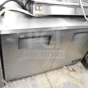 True TUC-48 Commercial 2 Door Undercounter Cooler with casters, 115V, 1 Phase, visible wear on stainless steel surface.