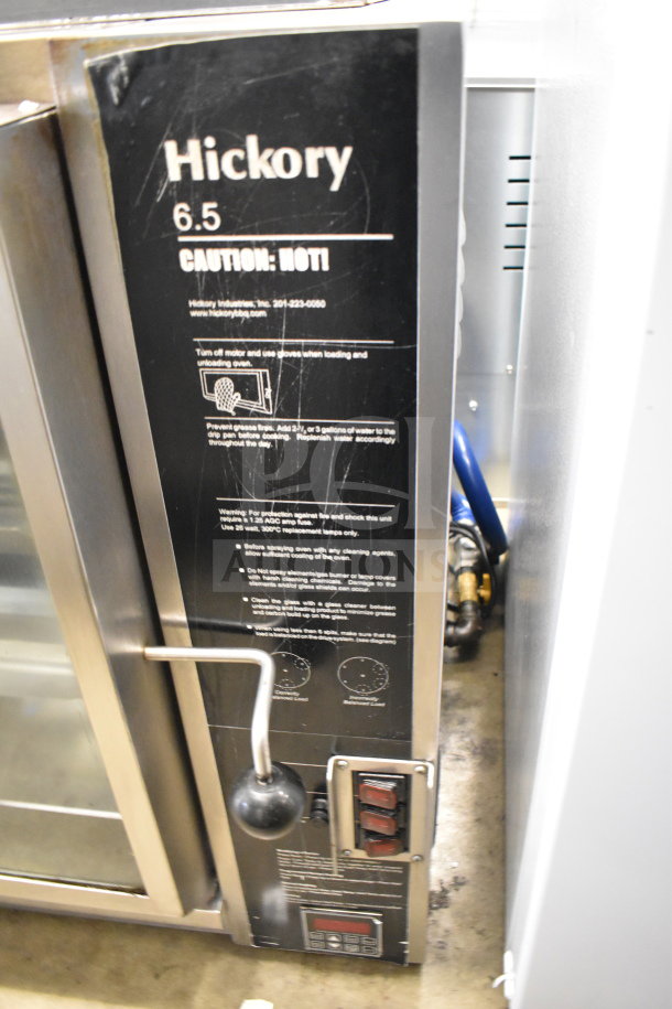 Old Hickory N/6.5G rotisserie oven, natural gas powered, with spits/skewers. Black panel displays operational instructions.