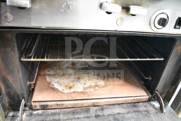 Jade Range gas-powered 6 burner range with salamander cheese melter, showing used condition interior with metal racks.