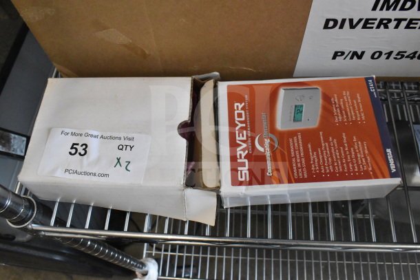 2 Surveyor CT414 commercial thermostats in original packaging, features visible; auction label "53 QTY 2" on box.