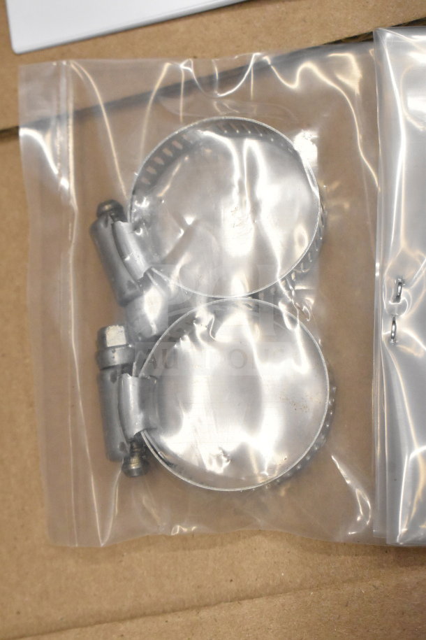 Top Mount Pedestal Kit in sealed plastic bag, includes metal clamps. New condition, ideal for secure mounting applications.