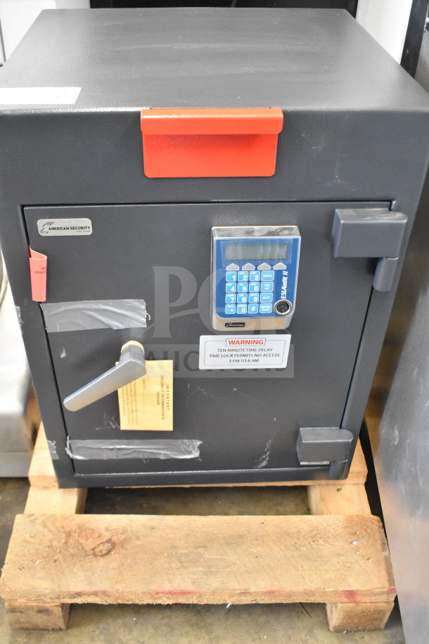 Commercial single compartment safe, gray, with key panel and handle. Labels indicate no combination provided. Good condition.