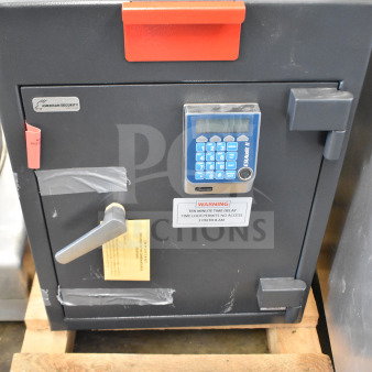Commercial single compartment safe, gray, with key panel and handle. Labels indicate no combination provided. Good condition.