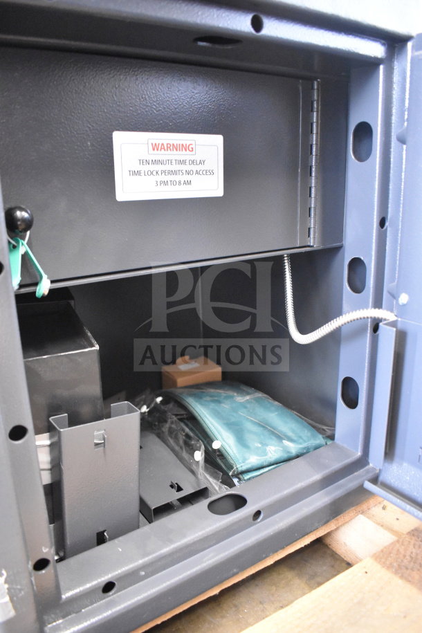 Commercial single compartment safe with internal storage items. Warning label on door. No combination included.
