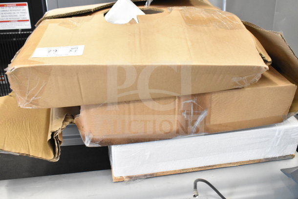 Three packed boxes including a wooden board, showing shipping labels and stacked arrangement, in used condition.