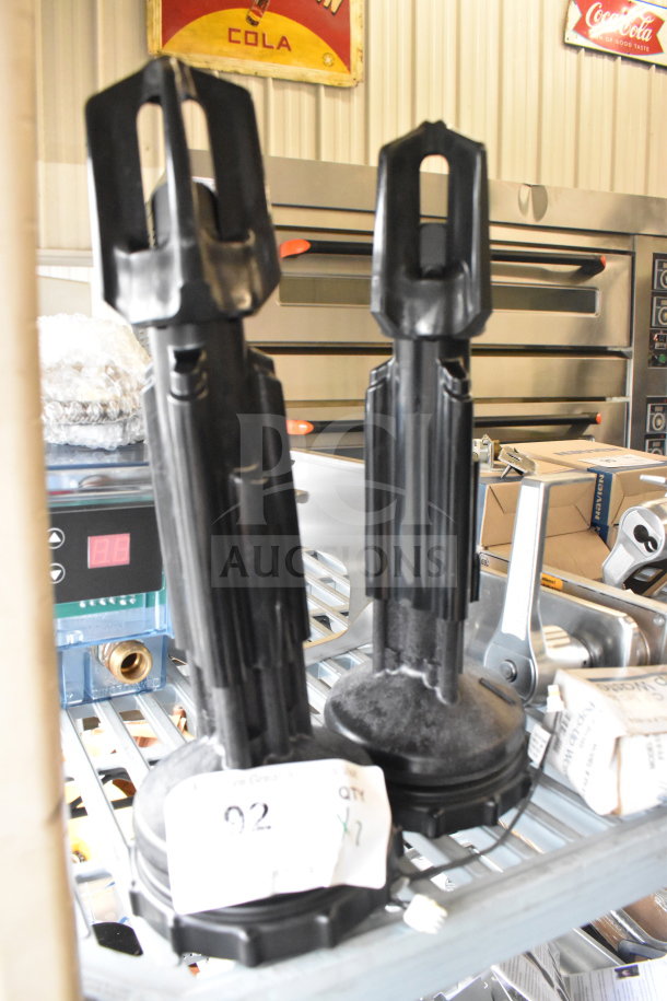 Two black industrial units with cylindrical bases and elongated tops, labeled "QTY x2," on metal shelving.