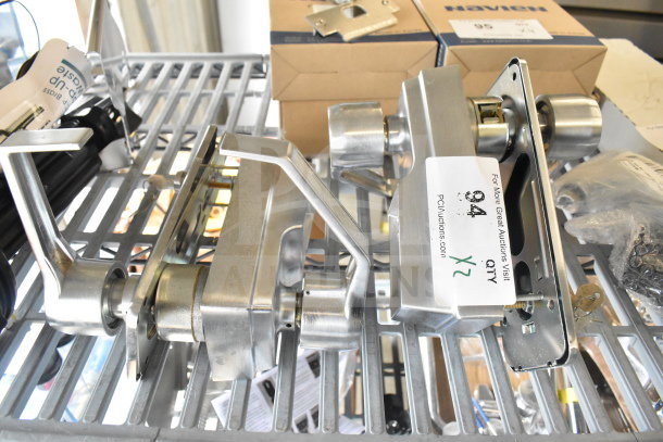 Stainless steel 2 door handles, rectangular design, new condition, labeled "x2," on metal shelf with hardware boxes.