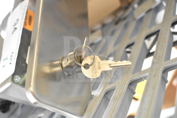 Stainless steel door handle with cylinder lock and key, labeled "Vega DR39". Auction tag on side.