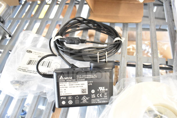 4 items including Navien exhaust plunge, Delta AC/DC adapter model MDS-030AAC24, cables, in original packaging.