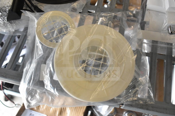 Four items including Navien exhaust plunge and Delta adapter, sealed in clear packaging, new condition, metal shelf background.