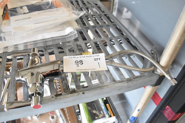 Chrome faucet handle with dual levers and braided hose, excellent condition, tagged as auction item 98 on metal shelf.