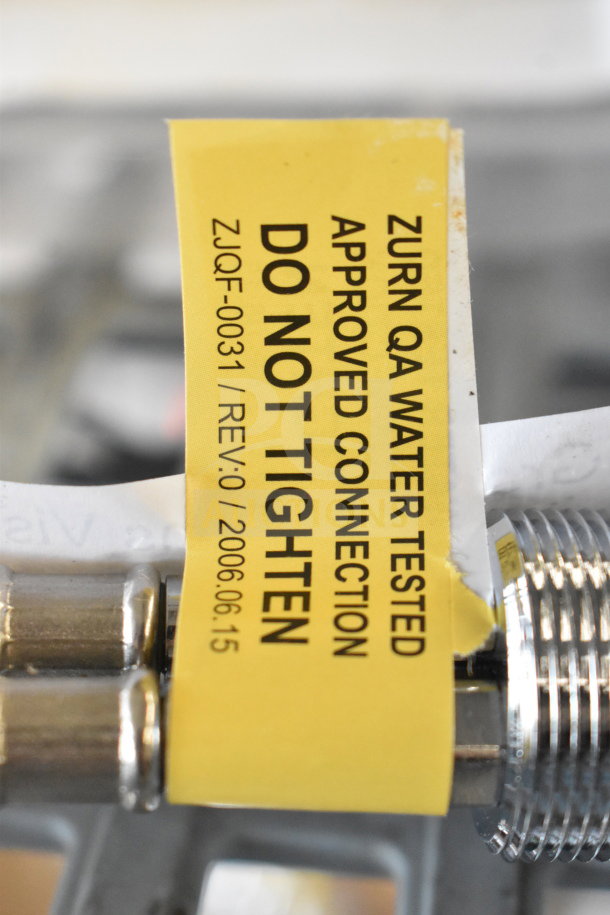Chrome coated handle with yellow label. Markings: "Zurn QA Water Tested, Approved Connection, Do Not Tighten, ZJQF-0031, Rev:0".