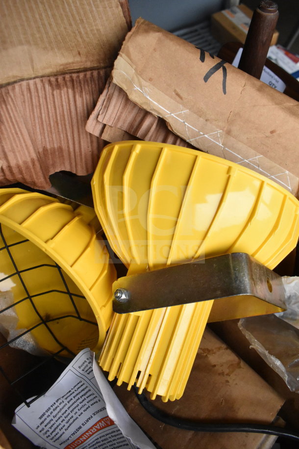 Yellow RP-H-40-P dock loading light with ribbed housing, metal bracket, and wire guard, in new condition.