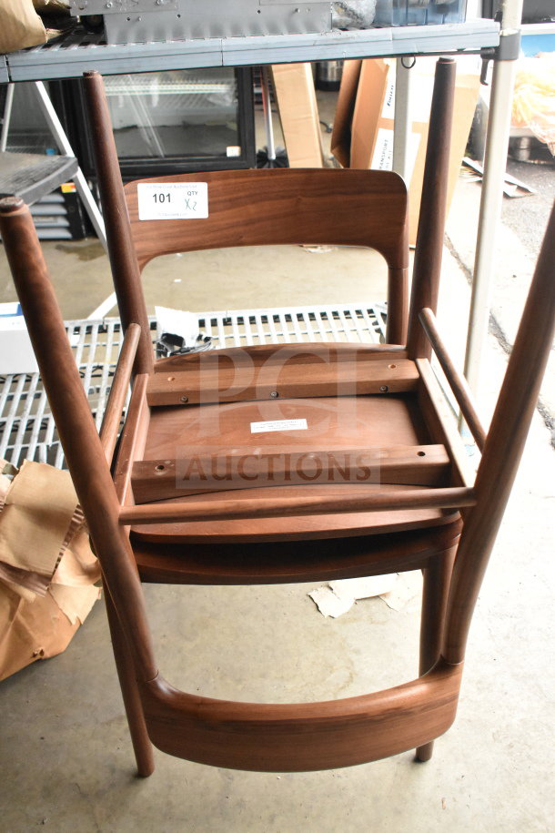 Two wooden dining height chairs, upside down, in good condition. Label shows quantity "X2".