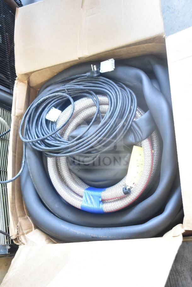 Cardboard box containing an insulation strip, coiled hose, and cable with connectors. Items appear in clean, unused condition.
